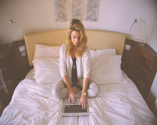 A person typing on a laptop with soft indoor lighting